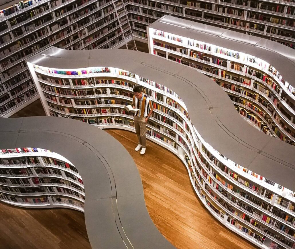 Mensch liest ein Buch in einer Bibliothek