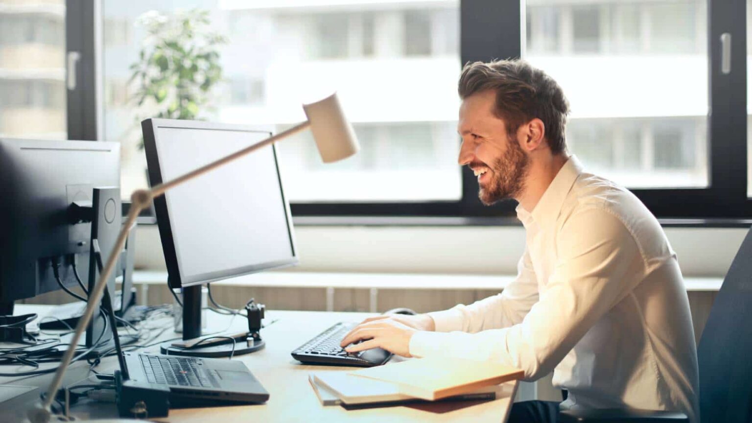 Glückliche Person in einem Büro am Schreibtisch