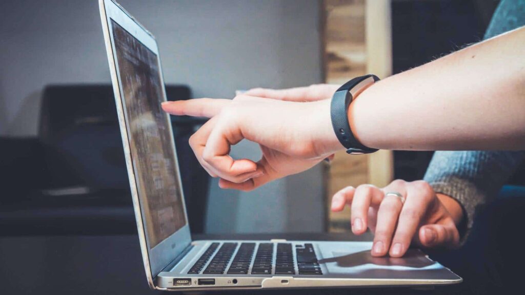 Zwei Personen arbeiten an einem Laptop